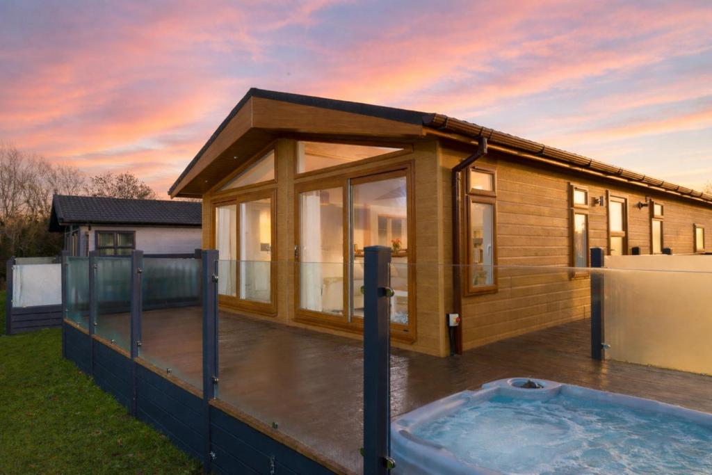 a house with a hot tub in the yard at Finest Retreats - Heron Luxury Lodge in Bourn