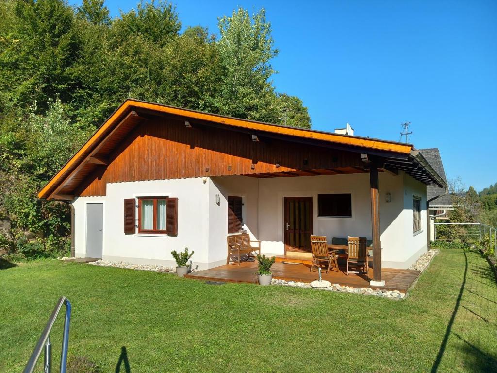 a small white house with a wooden deck at Ferienhaus in Maria Wörth