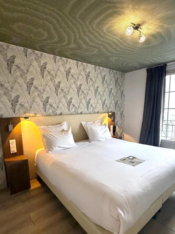a bedroom with a large white bed with a ceiling at Best Western Hotel Restaurant Ile de France in Château-Thierry