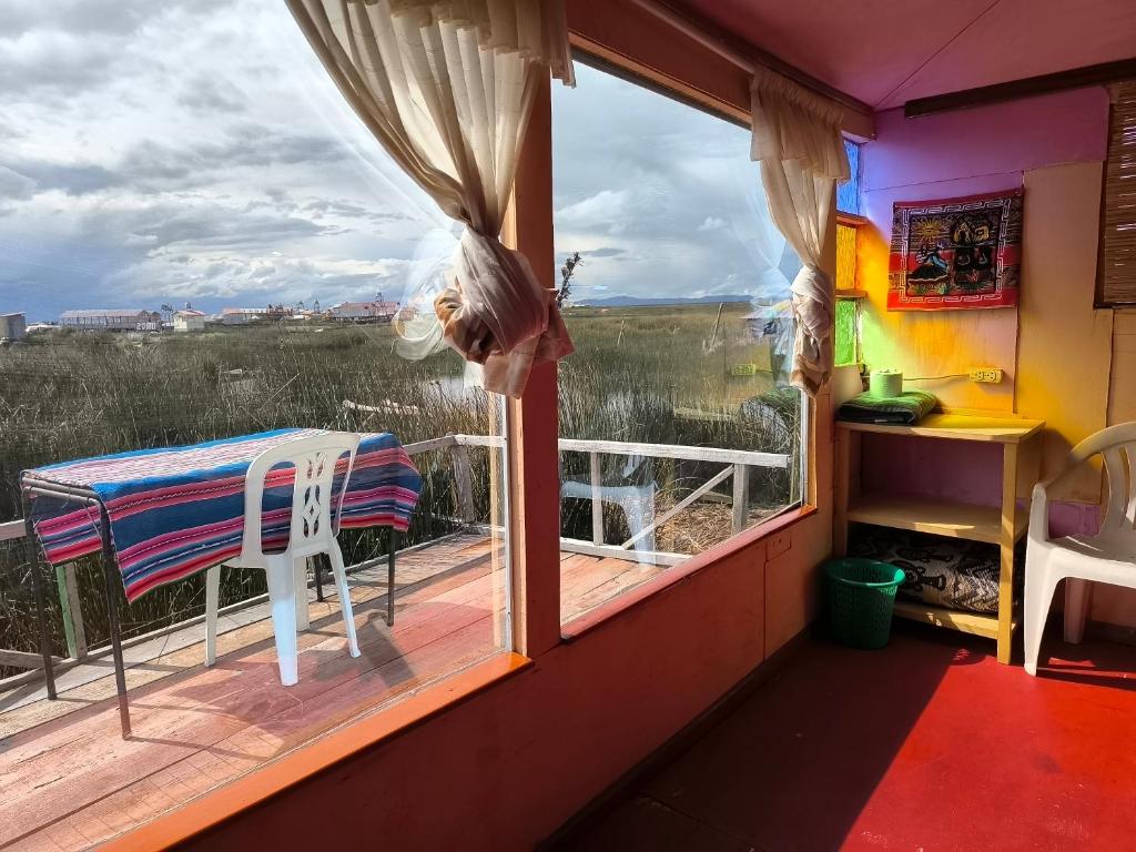 a room with a window and a table on a deck at Casa de Yolanda en Uros in Puno