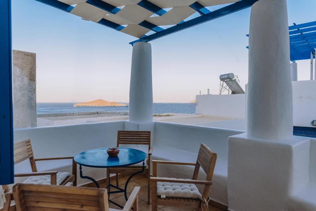 a table and chairs on a balcony with a view of the ocean at Folia in Agia Marina