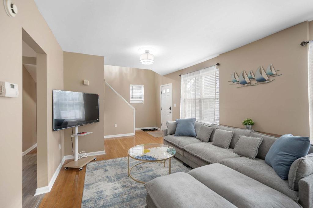 a living room with a couch and a flat screen tv at Tusculum Hilltop Haven For 8 in Cincinnati