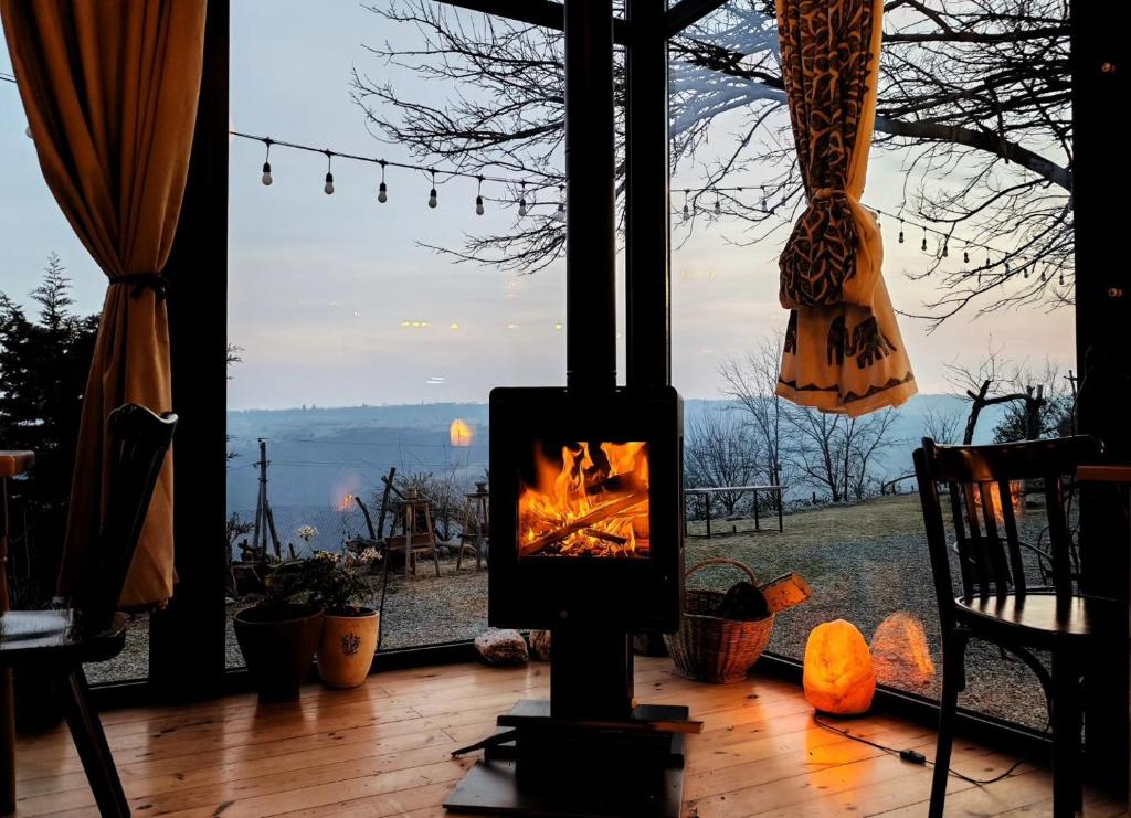 a fireplace in front of a window with a view at Lost Ridge Inn, Brewery & Ranch in Sighnaghi
