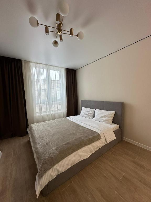 a bedroom with a bed and a ceiling fan at ЖК Сонячна Тераса in Ternopil