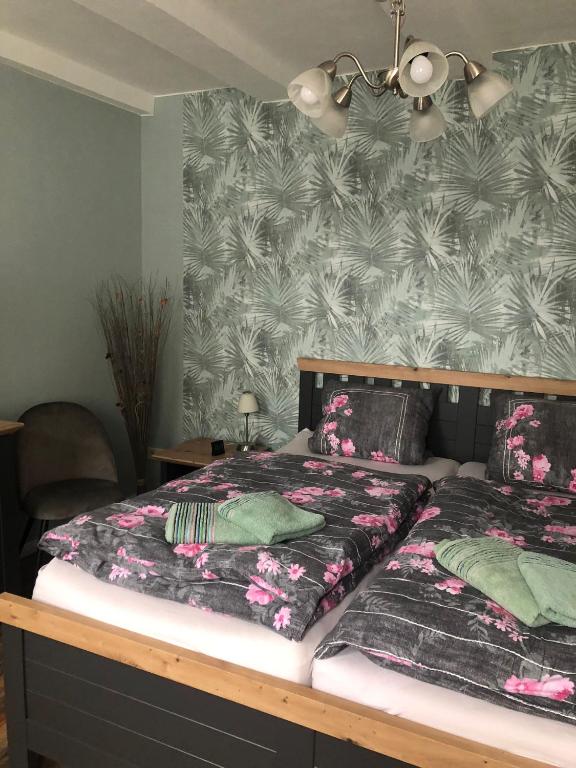 a bedroom with two beds and a tropical wallpaper at FeWo M Becker in Athenstedt