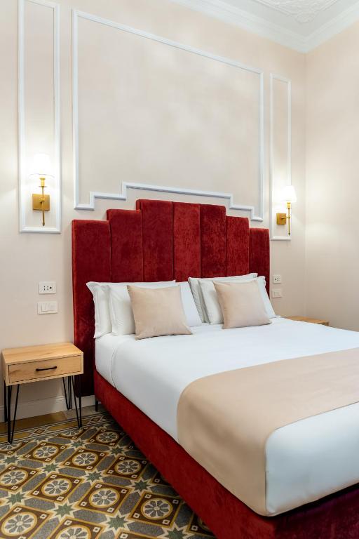 a bedroom with a large bed with a red headboard at Fiume 20 - Residence in Florence