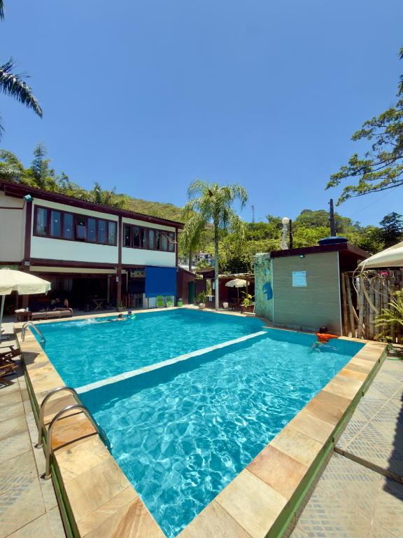 a large swimming pool with blue water at Recanto Verde Praia Hotel Juquehy in Juquei