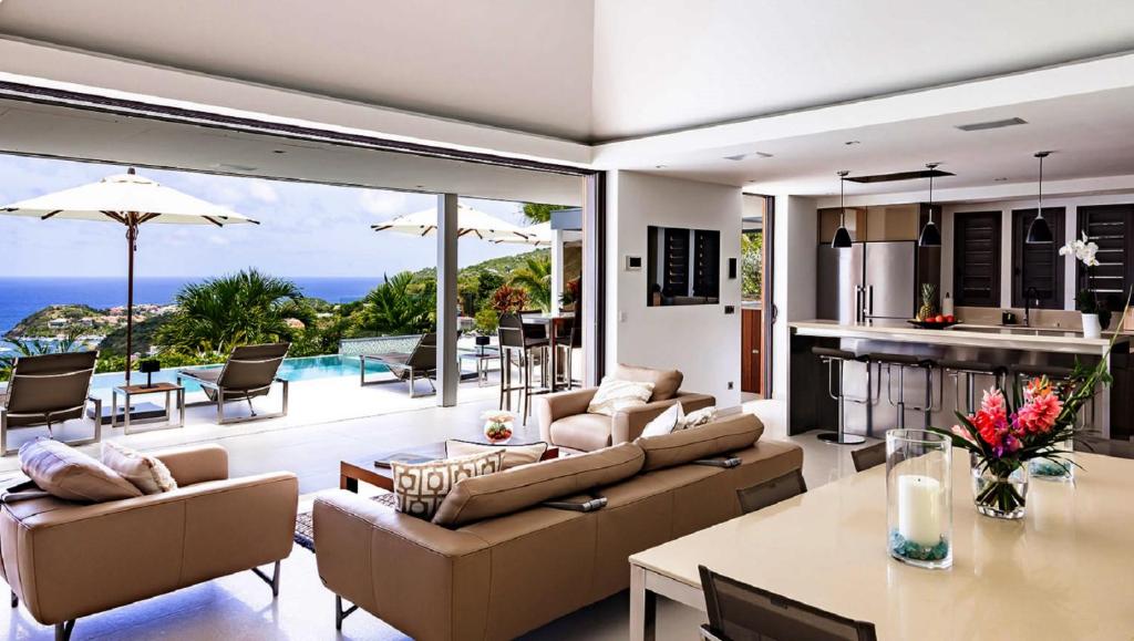 an open living room with a view of the ocean at Tropical heaven in Les Trois-Îlets