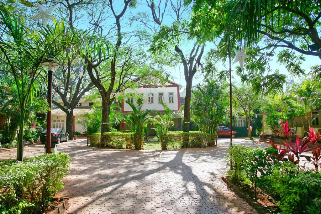 a cobblestone street with trees and a house at Hotel Malas in Panchgani