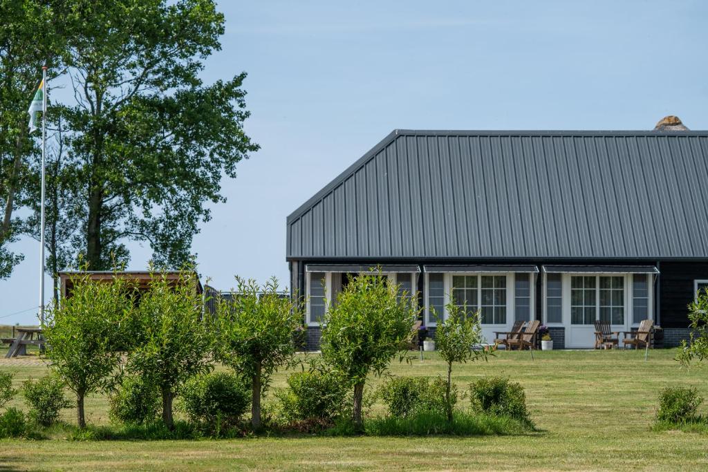 a black house with trees in front of it at Johanneshoeve - de mooiste plek op Texel in Den Hoorn