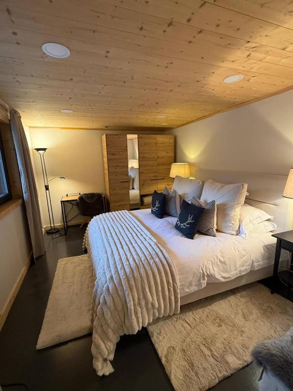 a bedroom with a large bed with a wooden ceiling at Little Chalet Piguet in Gryon