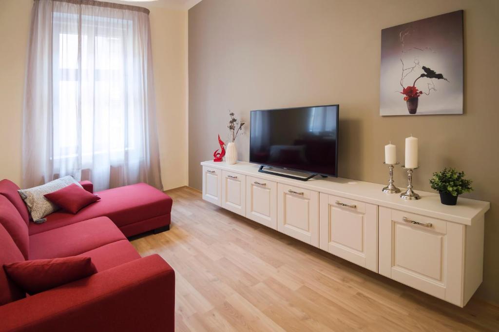 a living room with a red couch and a flat screen tv at Apartment Za Poricskou branou in Prague