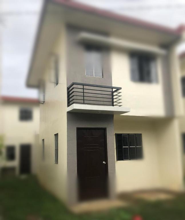 a close up of a house with a black door at Charming 2-Bedroom Balanga Getaway with Ample Space in Balanga