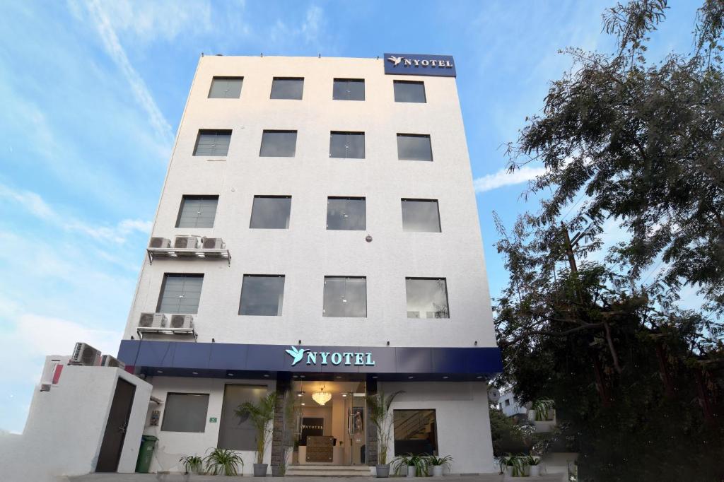 a tall white building with a sign on it at Nyotel-MP Nagar Bhopal in Bhopal