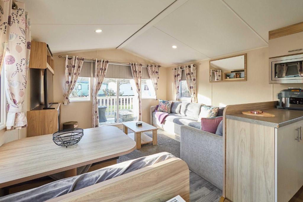 a caravan living room with a couch and a table at Host and Stay - 421 Wooler Park in Wooler