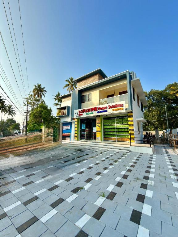 a building with yellow and green doors on a street at Sunshine Holidays in Varkala