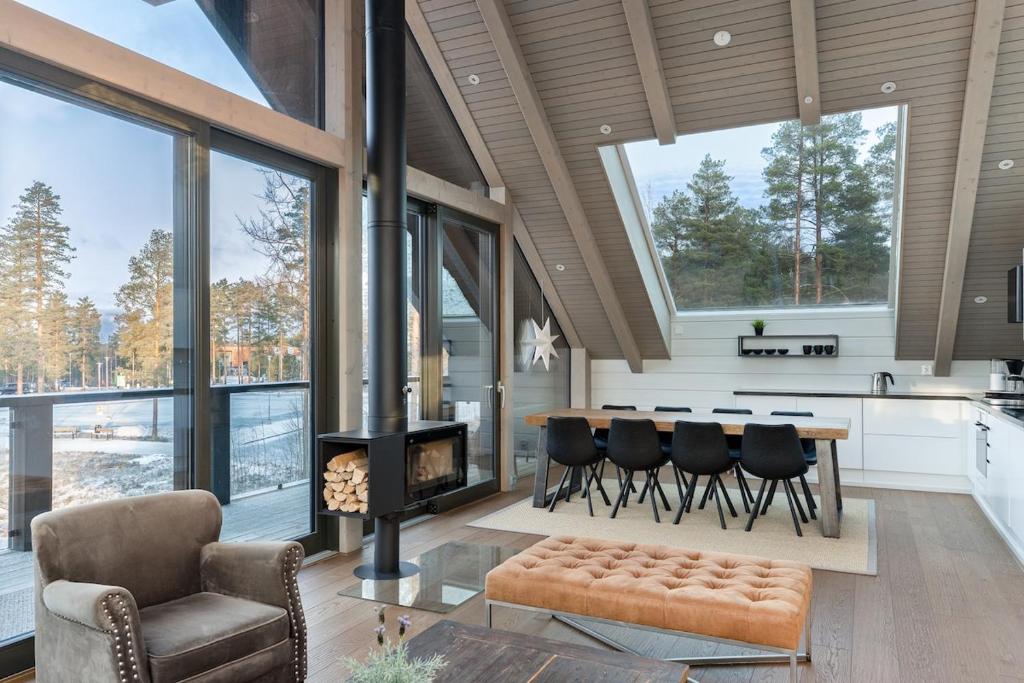 a living room with a fireplace and a table and chairs at Naava Chalet 401 Penthouse - Järvinäköala ilta-aurinkoon in Ähtäri