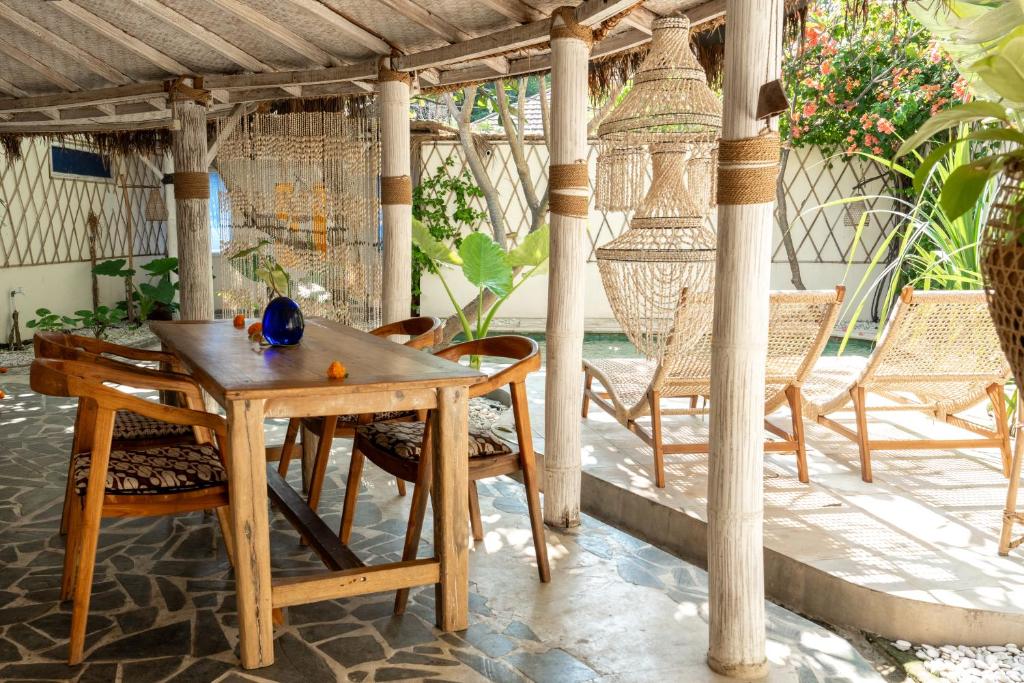 a wooden table and chairs on a patio at Pachamama Pool Villa in Gili Islands