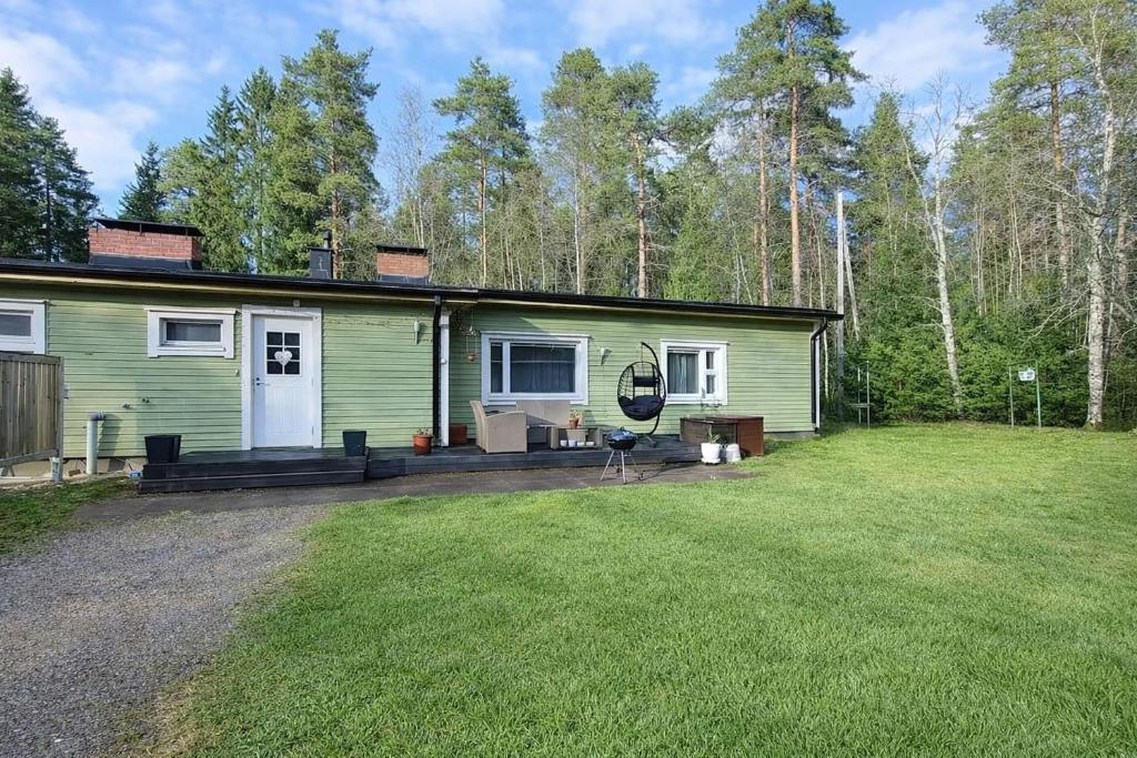 a green house with a yard in front of it at Lumi & Luonto - Entire 100 sqm 3-BR house with private wood fired sauna in Oulu