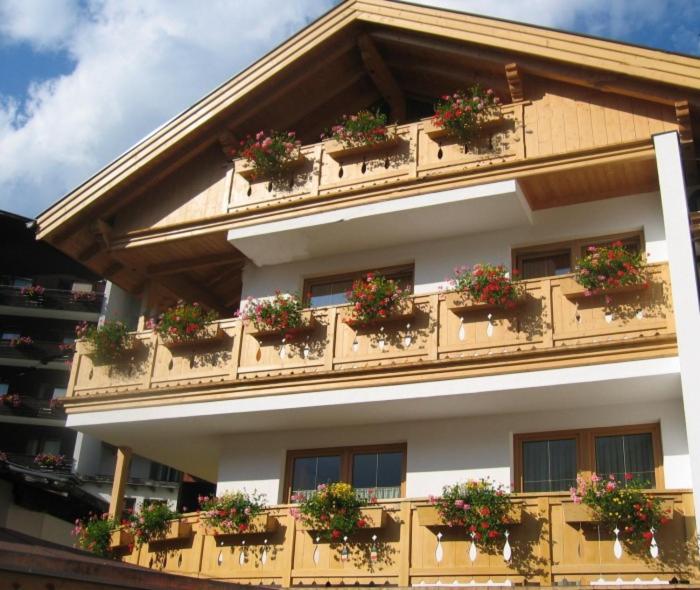ein Gebäude mit Topfpflanzen an den Fenstern in der Unterkunft Anton´s Appartements in Oetz