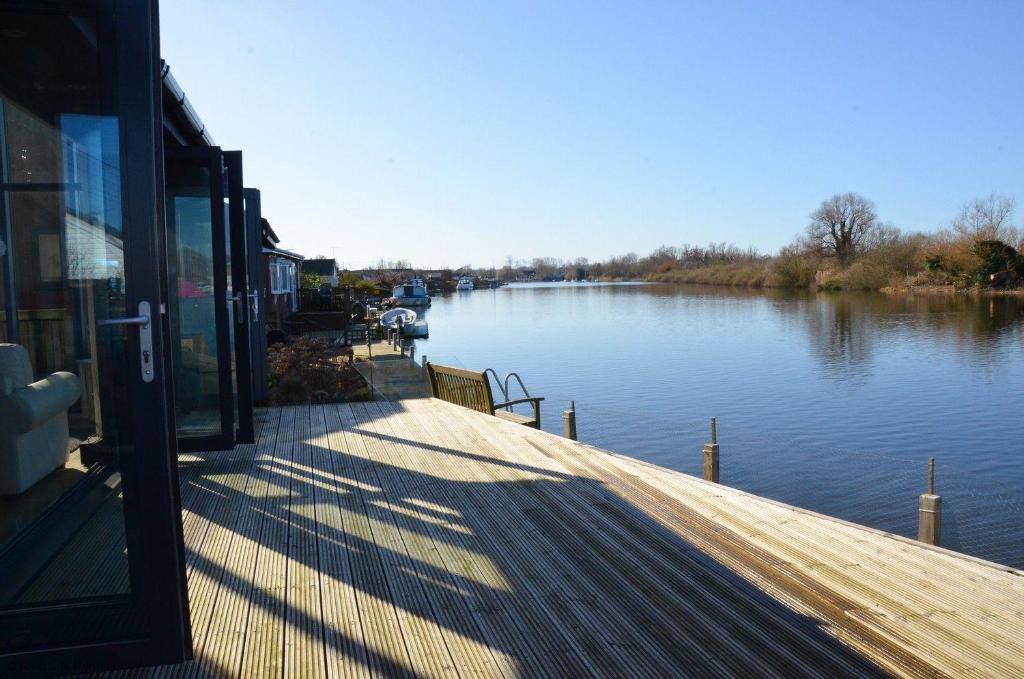 a boat dock with a view of a river at Riverside Lodge in Brundall