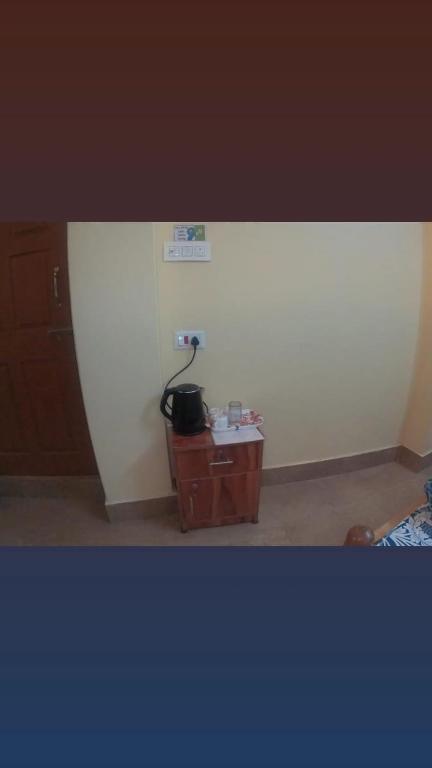 a room with a white wall and a wooden table at Hotel Pelican in Kalimpong