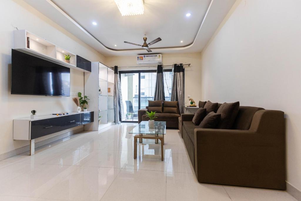 a living room with a couch and a tv at Indigo Studio by JadeCaps 1BHK New Town Kolkata in kolkata