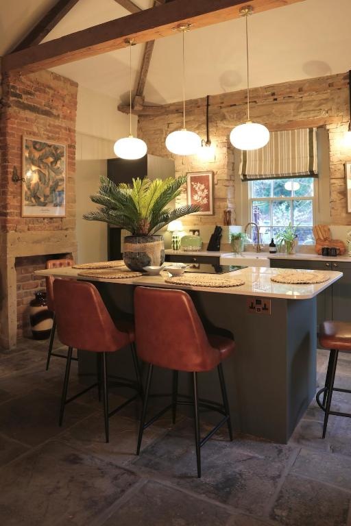 a kitchen with a large island with a table and chairs at Lock Keepers Cottage at Salterhebble in Exley