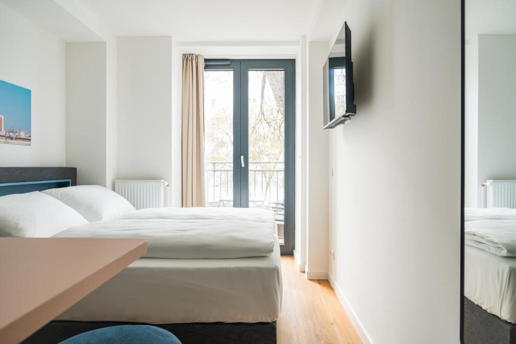 a hotel room with two beds and a window at Homaris Nolli Studios in Berlin