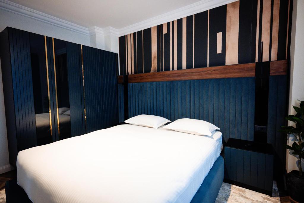 a bedroom with a white bed and blue walls at Ghica Boutique Suites in Vaslui