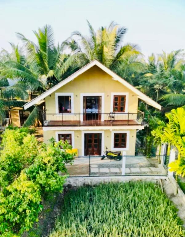 a house with palm trees in front of it at Pilgrims Nature Villa in Ahangama
