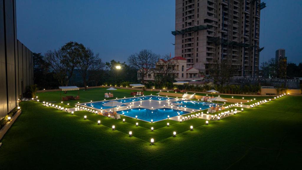 a large pool with lights in a park at night at Assembly By The Democracy in Nashik