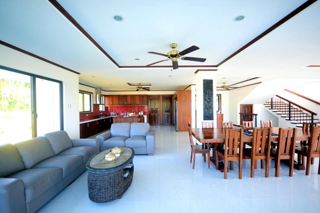 a living room with a couch and a table and chairs at Anapuro Elnido in El Nido