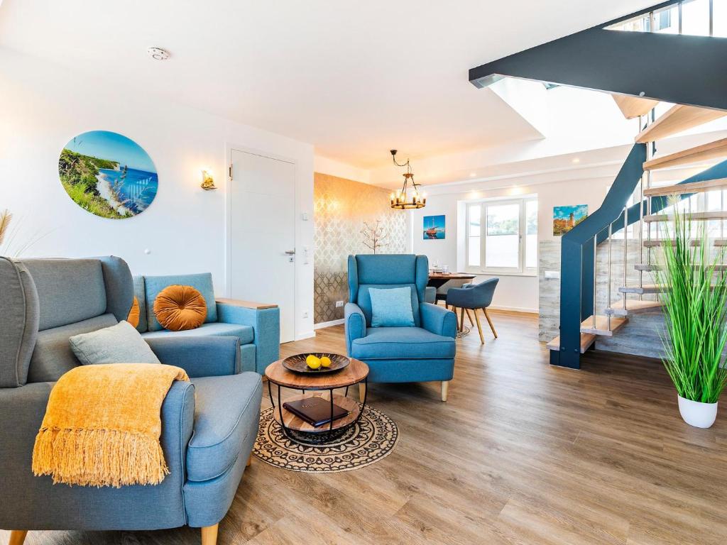a living room with blue furniture and a staircase at Prora - Ferienwohnung mit Waschmaschine - Meeresrauschen Dachterrasse in Binz