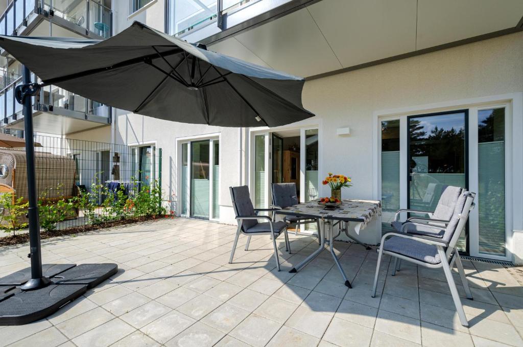 a patio with an umbrella and a table and chairs at Prora - Wohnung mit Terrasse - Proras Strandhaus in Binz