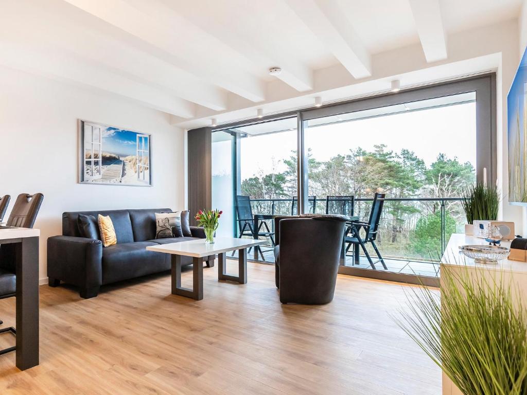 a living room with a couch and a table at Prora - Ferienwohnung mit Balkon und Waschmaschine - Dünenheide 3,3 in Binz