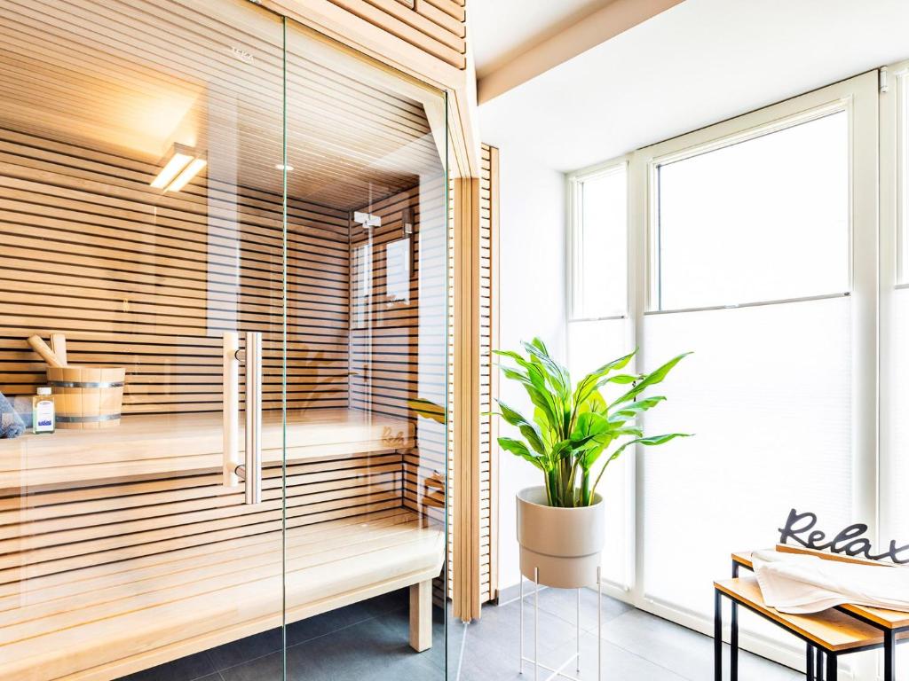 a sauna with a bench and a plant in a room at Prora - Apartment mit Sauna - Baltic Sunset in Binz