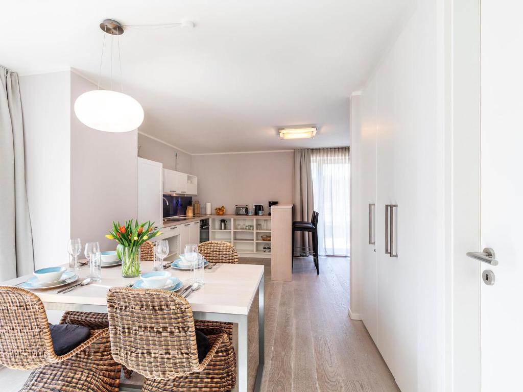 a kitchen and dining room with a table and chairs at Prora Block 1 - Ferienwohnung mit Pool, Sauna und Fitness - Sonnenschein in Binz