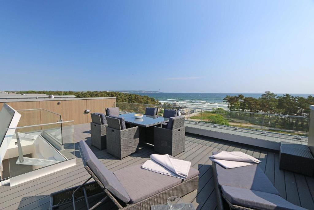 a patio with a table and chairs on a roof at Prora Block 1 - Sauna, Pool und Fitness - Meerzeit in Binz