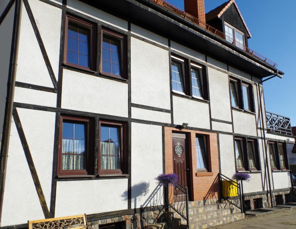 a white building with windows and a door at Dom Aptekarza in Ustka