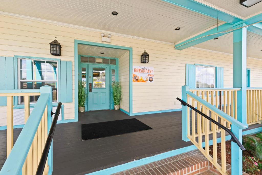 a front porch of a house with a blue door at Moonlight Inn Hotel O Hattiesburg, MS in Hattiesburg