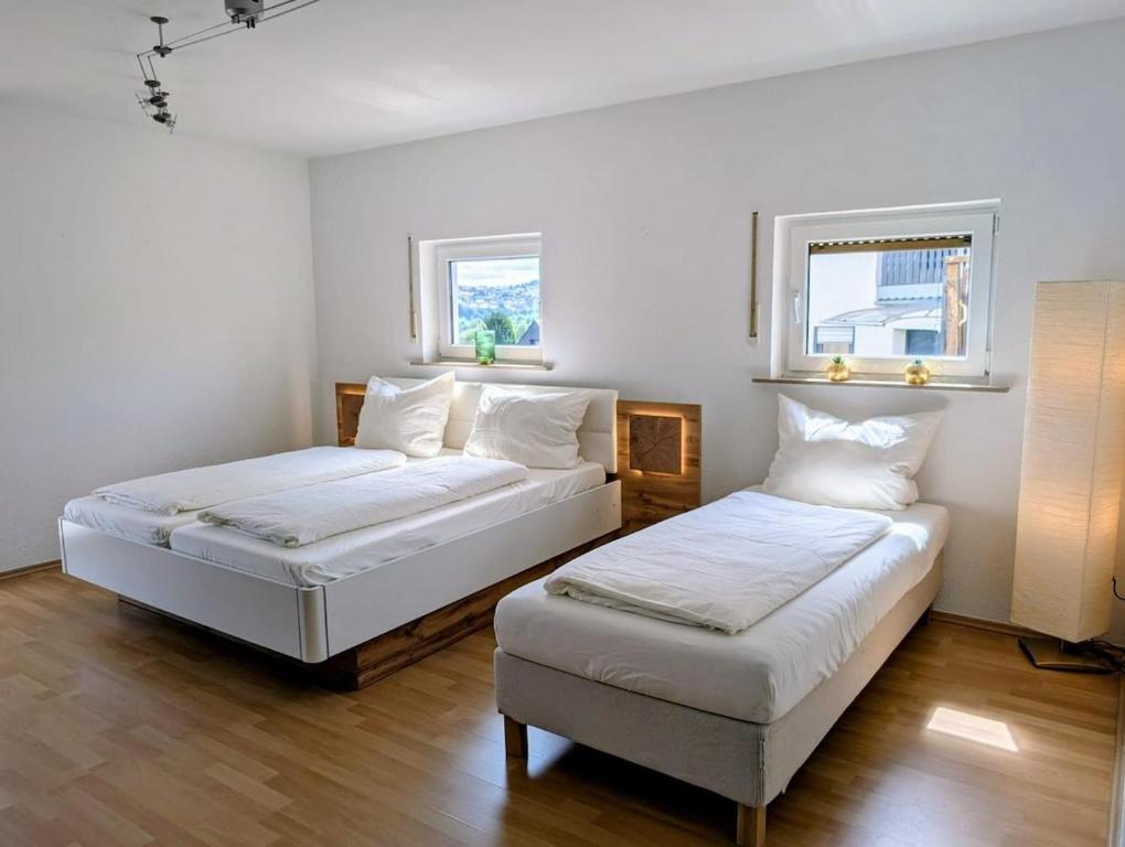 two beds in a room with two windows at Apartment Kadenbach in Kadenbach