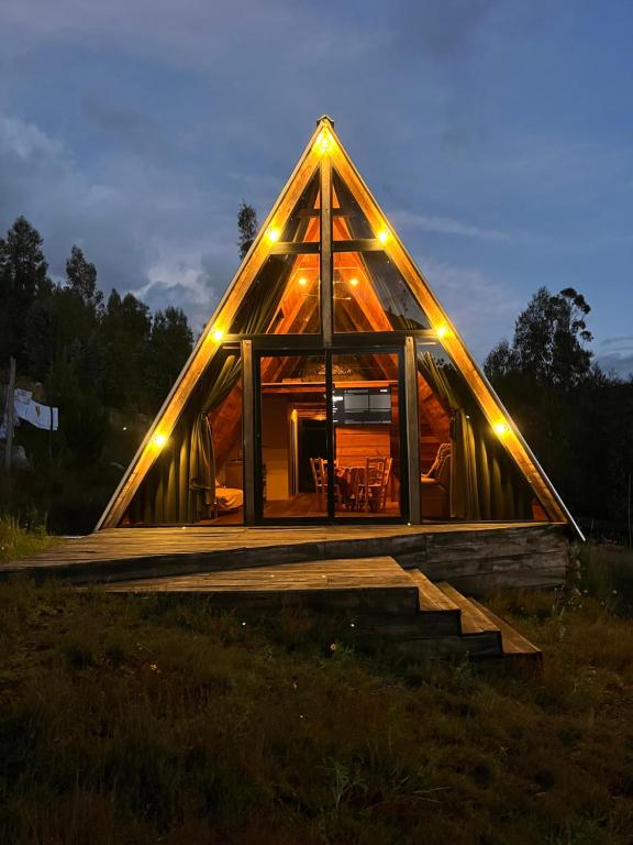 a large wooden house with lights on it at Conga Lodge Cabana Alpina in La Conga