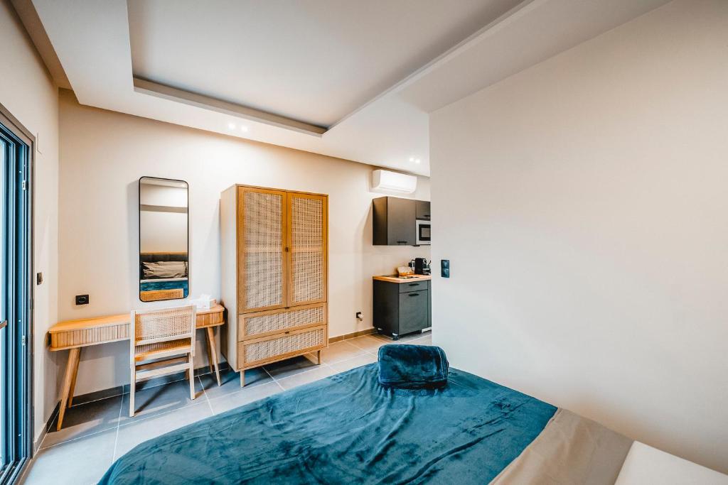 a bedroom with a bed and a desk and a table at Nima Suites Corfu in Marathias
