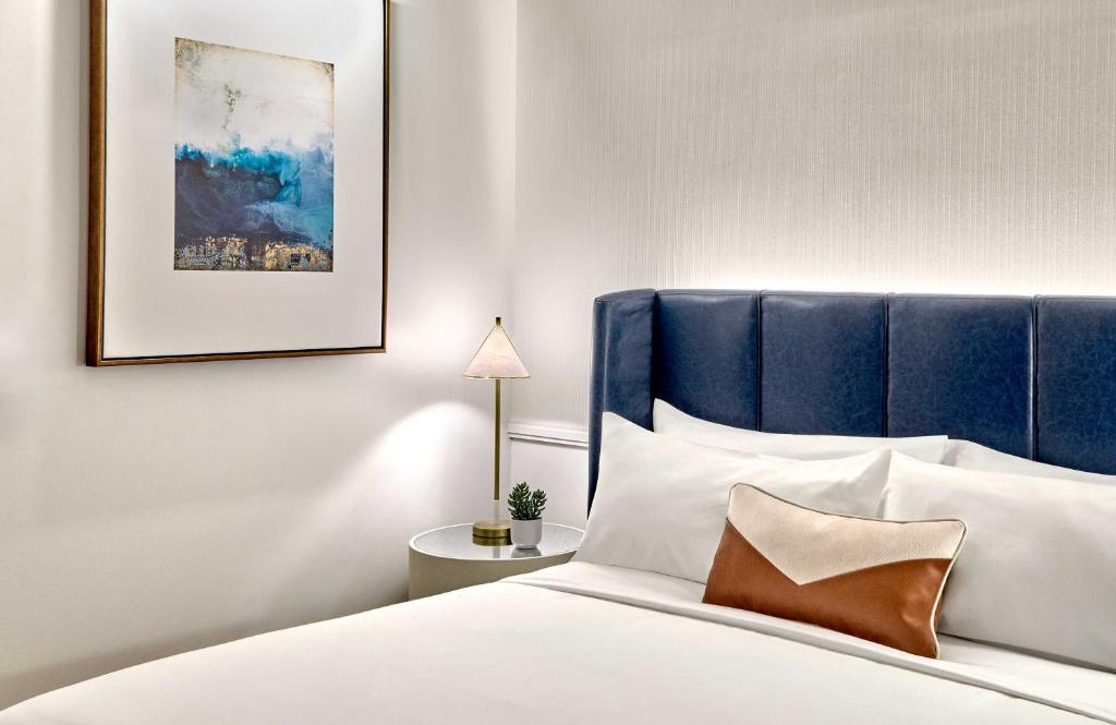 a bedroom with a bed with a blue headboard at Omni Fort Lauderdale Hotel in Fort Lauderdale