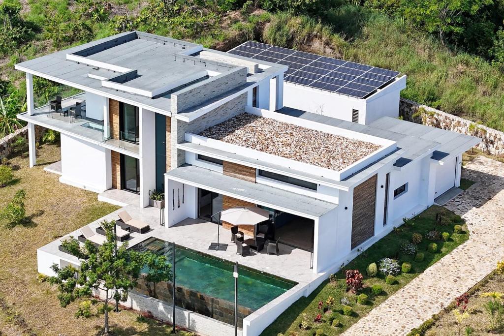 an aerial view of a house with solar panels on the roof at Passot Hills - Villas Premium in Nosy Be