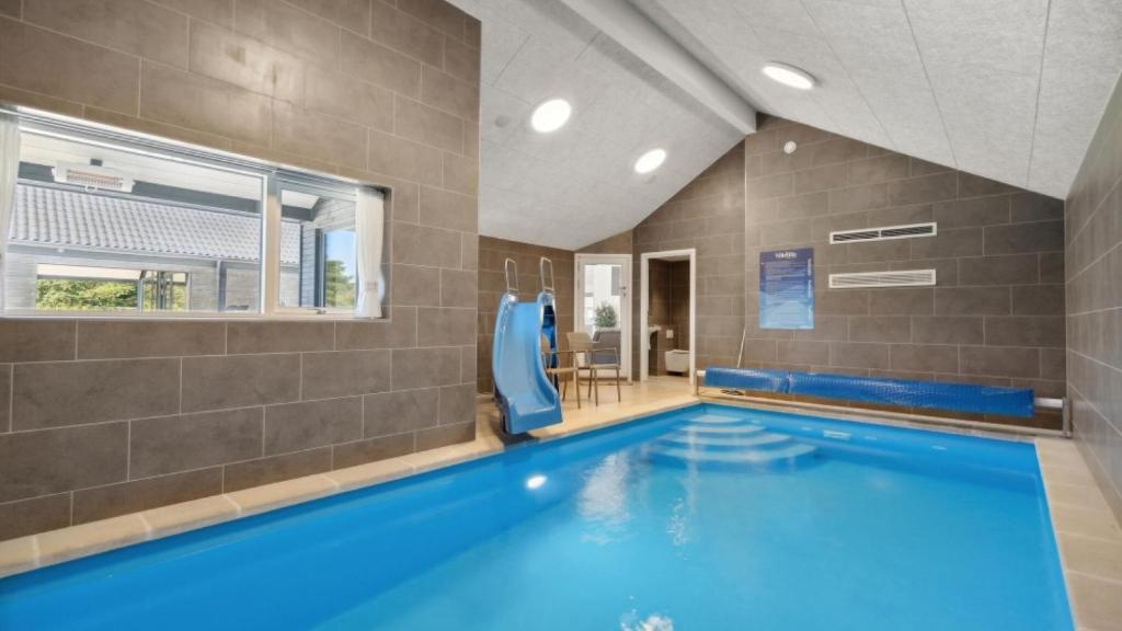 a large swimming pool with blue water in a room at Villavilla 596 - Rømø, Sydjylland in Høm
