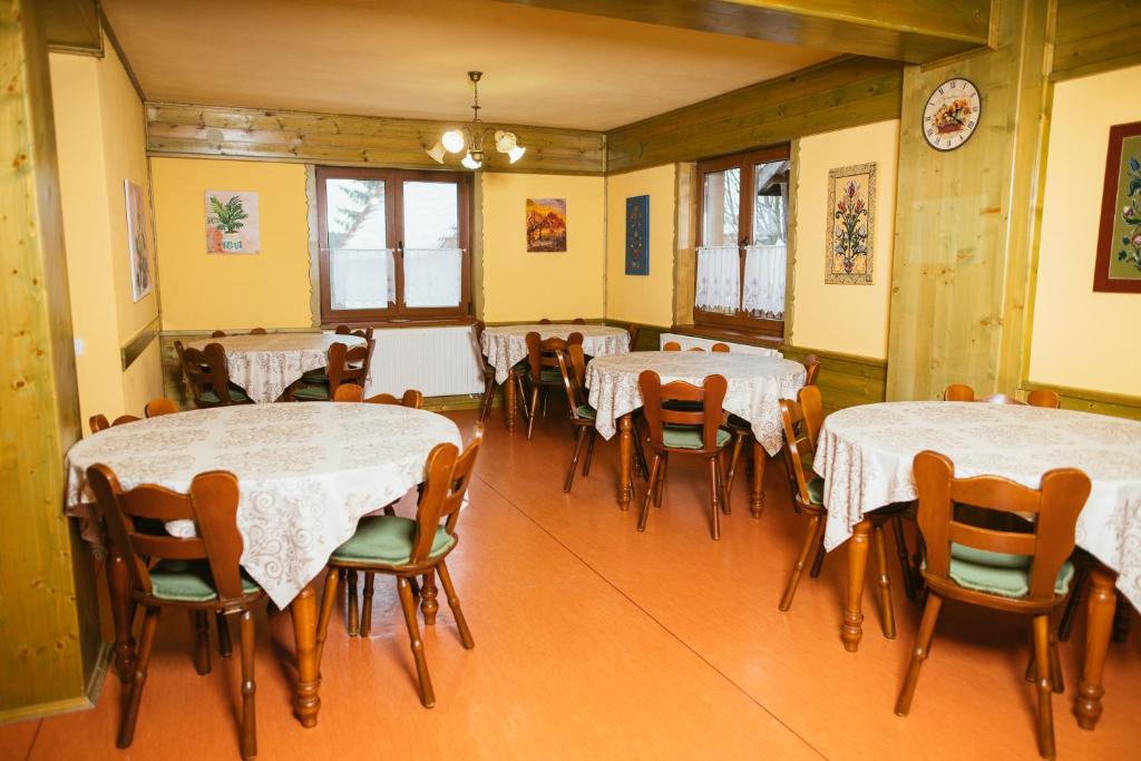 a dining room with tables and chairs in it at Zafir House Harghita Bai Ski in Harghita-Băi