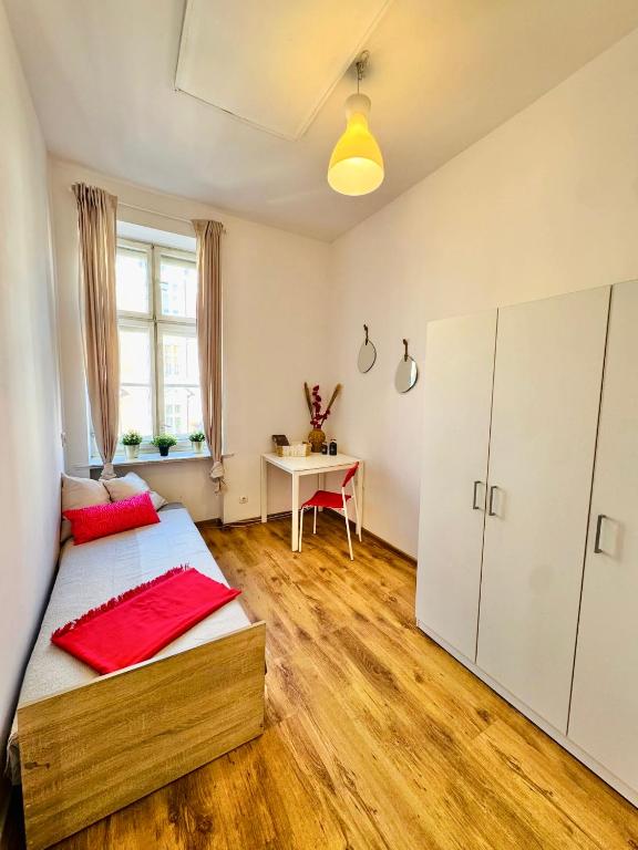 a bedroom with a bed and a table in it at Pokój przy Rynku ll in Katowice