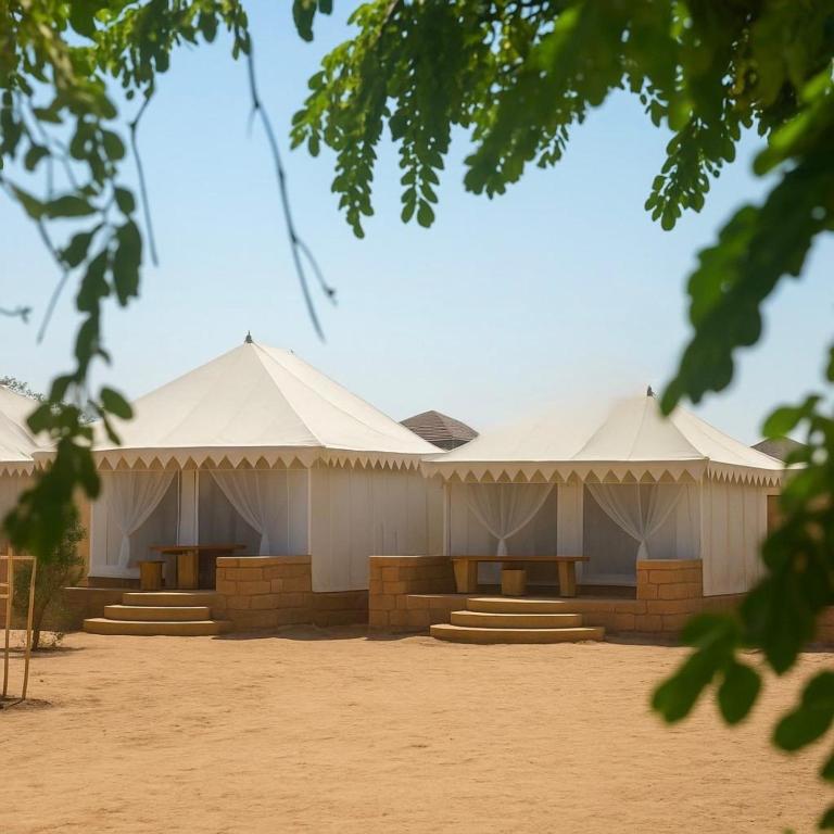 a group of white tents in the sand at Sunrise Resort Jaislamer in Jaisalmer